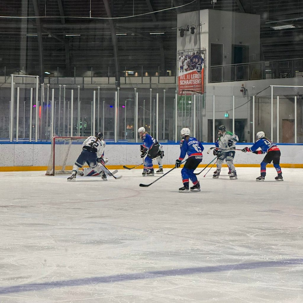 Speelster van Dordrecht Lady Lions probeert te scoren terwijl de goalie van UNIS Flyers Heerenveen redding brengt.
