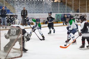 U9-spelers van Dordrecht Lions in duel met een speler van Amsterdam Tigers tijdens een aanval richting het doel.