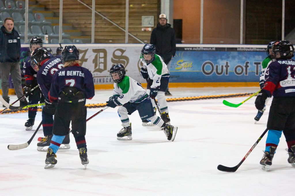 U9-spelers van Dordrecht Lions en HIJS Hokij strijden om de puck tijdens een wedstrijd in Den Haag.
