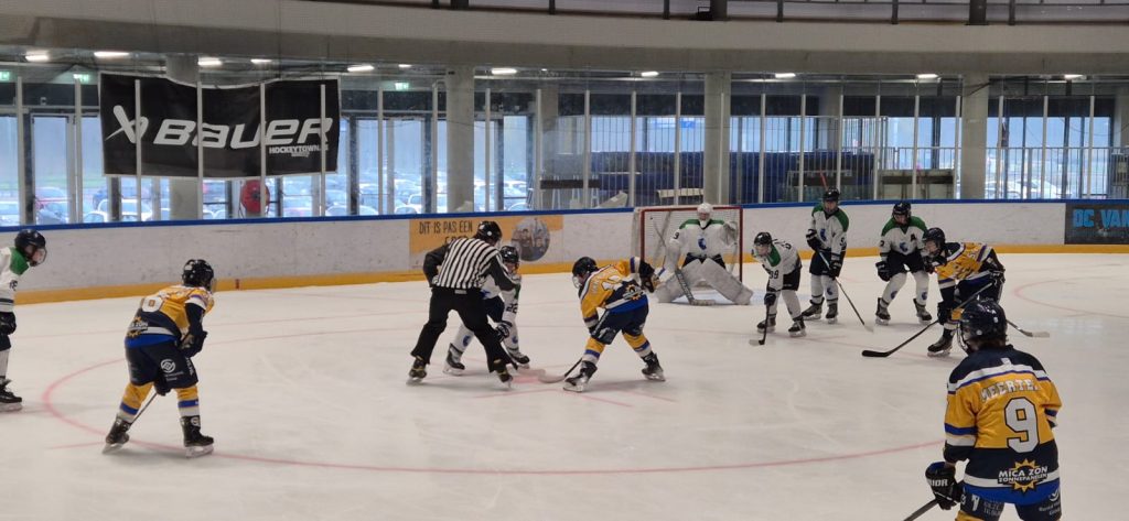 Face-off tussen Dordrecht Lions U15 en Tilburg Trappers U15 in de neutrale zone bij Optisport Sportboulevard Dordrecht.